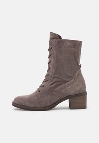 Taupe ruskind ankleboot med snørebånd foran, rund tå og stablet blokhæl på en hvid baggrund.