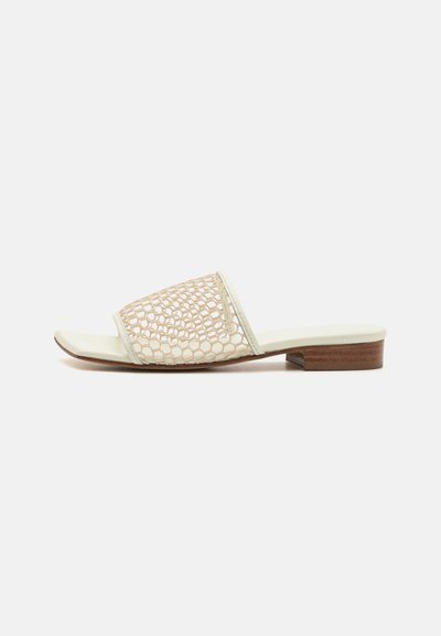 Beige open-toe instapsandaal met een mesh bovenzijde met een hexagonaal patroon, lichte zool en korte houten hak.