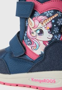 Niebiesko-różowe dziecięce buty z grafiką jednorożca, płatkami śniegu, rzepami i logo "KangaROOS" na krawędzi podeszwy.