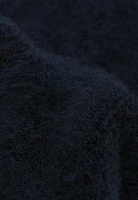 Mørkeblå strikket stof med en blød, fuzzy tekstur, der har tykke fibre, som skaber et tæt, varmt udseende.