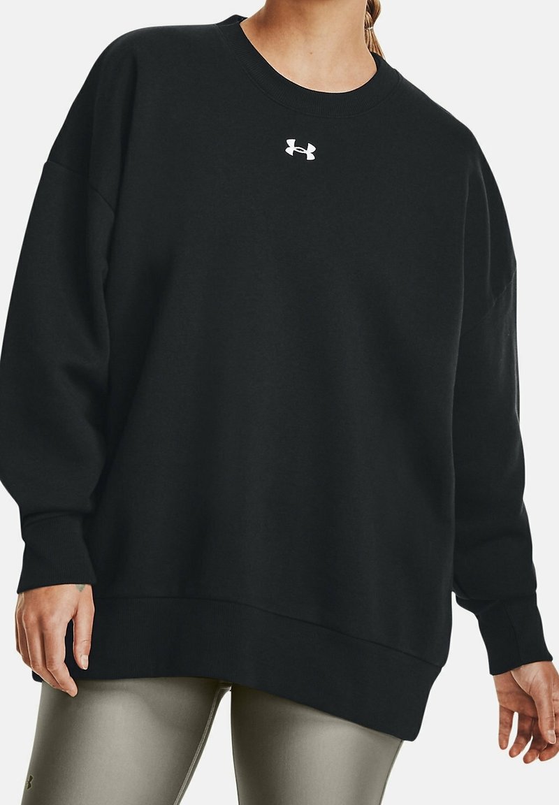 Sudadera negra de gran tamaño hecha de una mezcla de algodón, con cuello redondo ribeteado y pequeño logo blanco en el pecho. Textura suave.