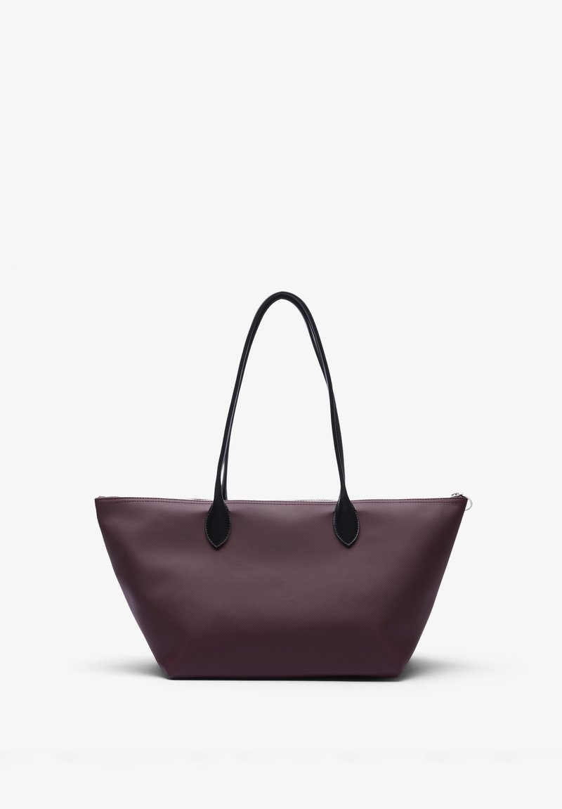 Duża torba na ramię w kolorze burgundowym, wykonana z gładkiego materiału. Posiada czarne uchwyty oraz zamek błyskawiczny, w kształcie trapezu.
