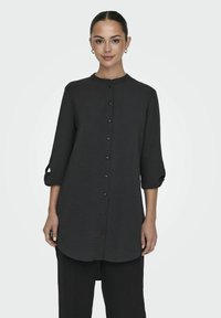 Zwarte longsleeve shirt met een opstaande kraag, knopen aan de voorkant en opgerolde mouwen. Geverfde stof met een afgeronde zoom.