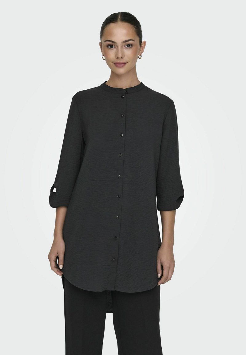 Black long-sleeve shirt with a mandarin collar, front buttons, and rolled sleeves. Textured fabric with a rounded hem.