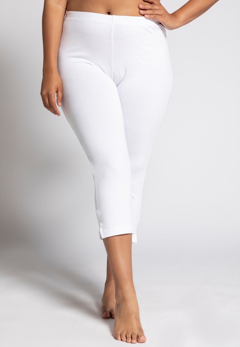 Leggings capri bianchi, elasticizzati, realizzati in tessuto liscio e morbido. Presentano una lunghezza fino al polpaccio con una semplice finitura dell'orlo.