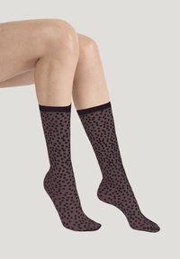 Kousen tot aan de knie, gemaakt van doorschijnende stof met een zwart polkadotpatroon op een donkere achtergrond; met een effen zwarte band aan de bovenkant.