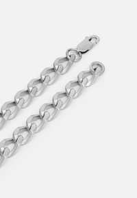 Zilveren ketting met in elkaar grijpende schakels, met een gladde afwerking en een veilige sluiting, weergegeven tegen een witte achtergrond.