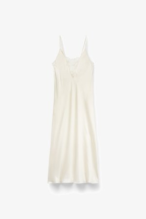 Robe slip en satin couleur crème avec des bretelles fines et des détails en dentelle sur le décolleté en V profond, présentée sur un fond blanc.