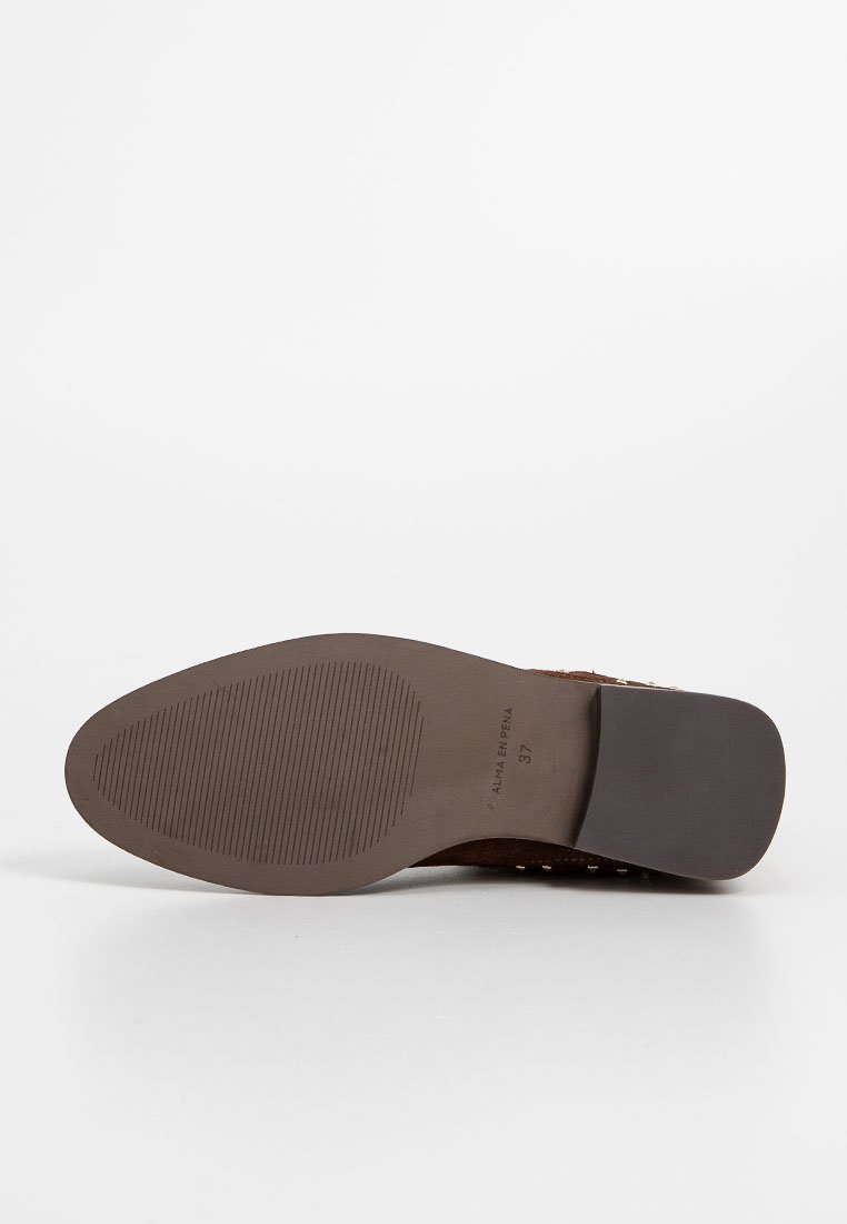 Braune Wildledersohle mit glatter Oberfläche. Verfügt über eine strukturierte Unterseite für Traktion und einen leichten Absatz mit geprägtem Branding.