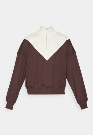 Brun og kremet half-zip genser med V-formet fargeblokkmønster, ribbede mansjetter og en myk tekstur.