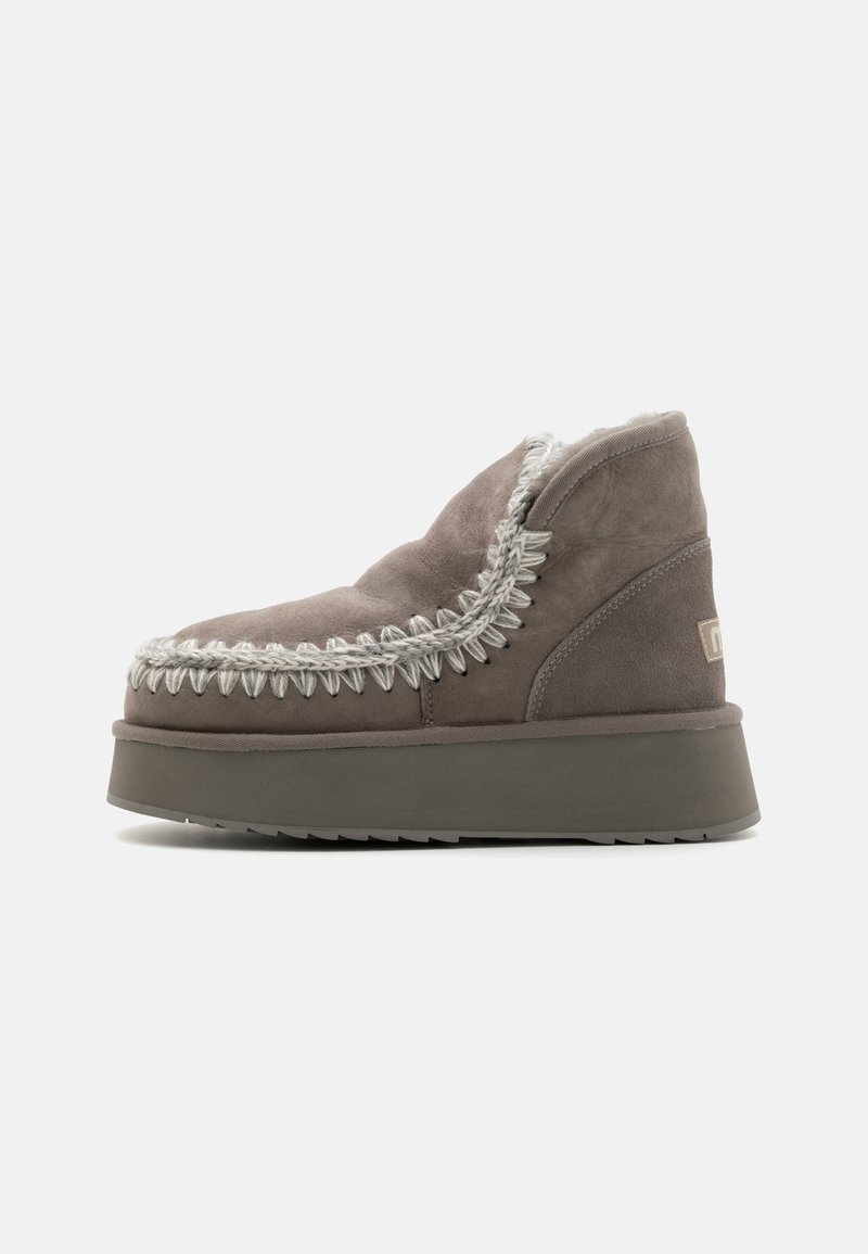 Stivaletti in suede grigio caratterizzati da una suola spessa, cuciture decorative attorno alla parte superiore e un interno foderato per il calore.