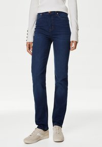 Mörkblå jeans med hög midja och rak bendesign. Har kontrastsömmar, klassisk femficksstil och en framknäppning.