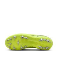 Suela de botas de fútbol verdes con múltiples clavos plateados, superficie texturizada con patrones en relieve y forma aerodinámica para mejorar la tracción.