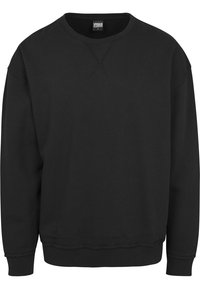 Sweat-shirt noir à manches longues avec col rond, poignets et ourlet côtelés, présentant un petit détail en forme de V cousu sous le col.