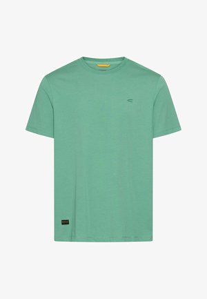 Prosty zielony bawełniany T-shirt z krótkim rękawem, okrągłym dekoltem i małą czarną metką marki przy dolnym brzegu na białym tle.