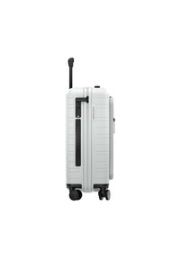 Hard-shell suitcase in white, featuring a textured surface, retractable handle, and four spinner wheels. Includes a combination lock.