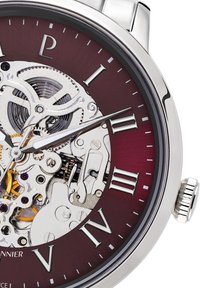 Reloj automático con esfera burdeos, números romanos plateados y movimiento mecánico expuesto. Caja y corona de acero inoxidable pulido.