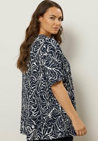 Marineblauwe en witte blouse met een patroon en korte mouwen, met een golvend bladmotief, een relaxte pasvorm en een zachte stoftextuur.