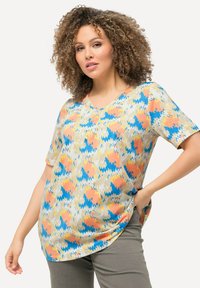 Camiseta de manga corta con escote en V, hecha de un tejido liviano, que presenta un colorido patrón en zigzag en tonos de melocotón, azul y amarillo.