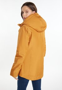Giacca arancione con cappuccio, realizzata in tessuto liscio e resistente all'acqua. Dotata di chiusura con zip, polsini elastici e vestibilità comoda.