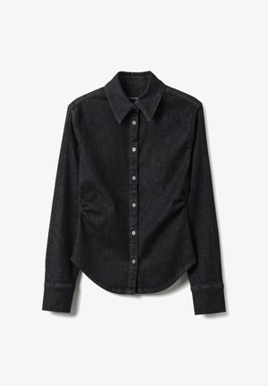 Zwarte blouse met lange mouwen, knoopsluiting, puntige kraag, getailleerde taille en zichtbare steken, plat gelegd tegen een witte achtergrond.