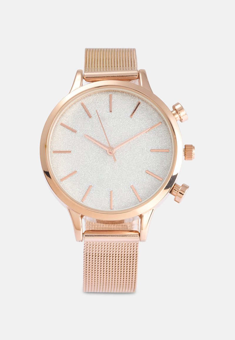 Rose gold metal ur med en rund urskive, hvid tekstureret skive, slanke timemarker og netrem. Tre små sideknapper til funktion.