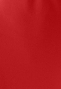 Rode stof met een gladde, matte textuur, die een uniforme kleur zonder patronen of zichtbare naden toont. Ideaal voor lichte kleding of accessoires.