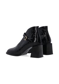 Zwarte gepatineerde leren enkellaarsjes met een krokodillenstructuur, vierkante blockhakken en een band met een gouden sluiting.