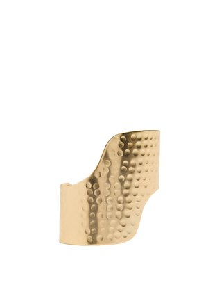 Bransoleta mankietowa z młotkowanego metalu w kolorze złotym z nieregularnym falistym wzorem krawędzi i teksturowaną kropkowaną powierzchnią.