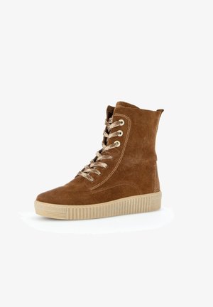 Bruine suède hoge sneaker met beige veters en dikke beige rubberen zool, schuin naar links op witte achtergrond.