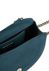 Borsa a tracolla blu in suede con chiusura a scatto, tracolla a catena e una tasca interna, che mostra una texture liscia e una forma arrotondata.