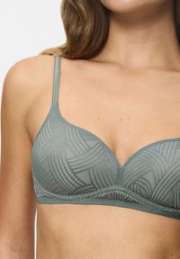 Reggiseno triangolare in morbido mesh verde chiaro, con un motivo a onda testurizzato, spalline regolabili e una fascia sottostante liscia che offre un supporto confortevole.