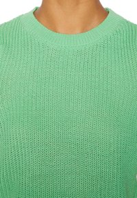 Jasnozielony sweter dzianinowy z okrągłym dekoltem, charakteryzujący się luźnym, otwartym splotem i ściągaczem wzdłuż dekoltu i dołu.
