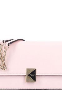 Pale pink leather handbag with a gold-tone hardware accent. Features a black strap and a geometric logo patch on the front. Smooth texture.