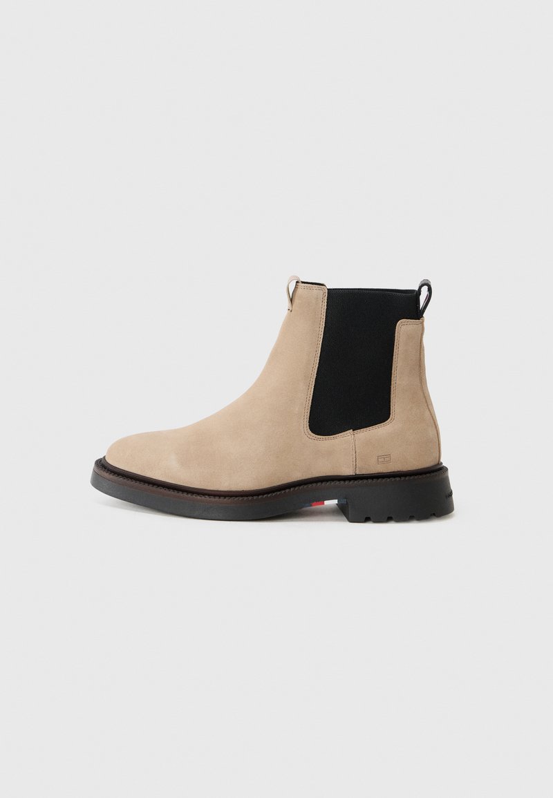 Bocanc din suede bej Chelsea cu panouri laterale elastice negre, braț de prindere, vârf rotunjit, talpă din cauciuc robustă și detalii de cusătură pe margine.