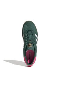 Vihreät mokkakengät, joissa on valkoiset raidat, vaaleanpunaiset yksityiskohdat ja teksturoitu kieli. Varustettu pehmeällä pohjallisella ja pyöristetyllä kärjellä.