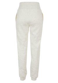 Hellgraue Jogginghose mit weichem Texture, elastischem Bund und Seitentaschen mit cremefarbenen Akzenten. An den Knöcheln schmal zulaufende Bündchen.