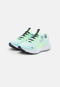 Baskets de course vert clair avec tige en mesh, accents noirs et lacets vert lime lumineux. Présentent un bout arrondi, une semelle rembourrée et un logo visible.