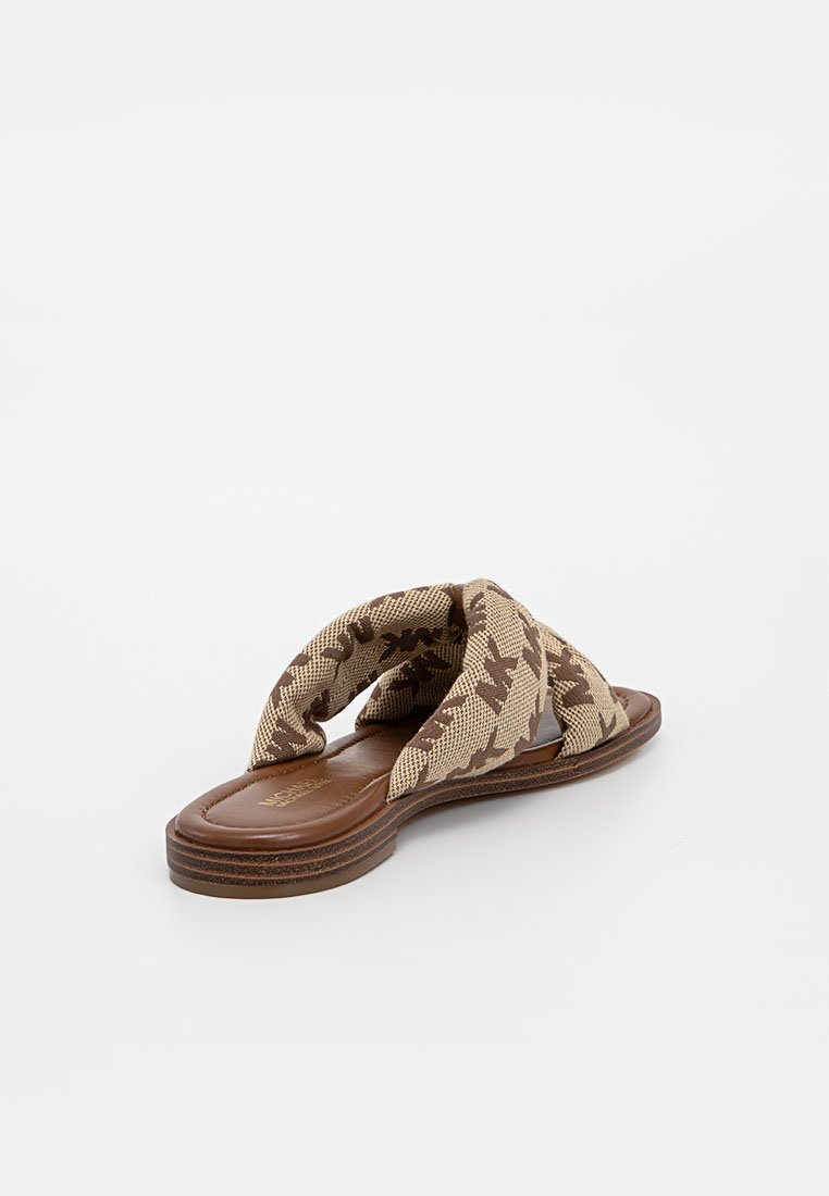 Braune Rutsch-Sandalen mit einem geflochtenen beigen Obermaterial, das ein Sternenmuster aufweist, einer gepolsterten Sohle und einem offenen Zehenbereich.