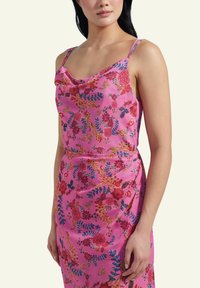 Floral pink dress with a draped neckline, featuring vibrant red and blue flowers. Lightweight fabric and thin spaghetti straps.