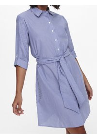 Abito a righe blu e bianco con colletto, maniche a tre quarti, chiusura con bottoni e dettaglio in vita annodato per una forma definita.