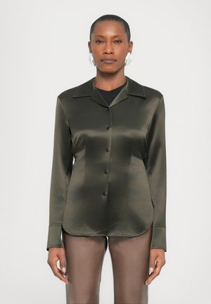Dark green satin shirt with a pointed collar, button closure, and long sleeves. Smooth texture; fitted silhouette.