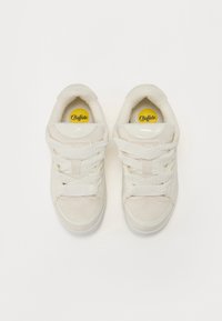 Adidași albi cu un superior din piele netedă și nubuc, având șireturi împletite, guler căptușit și un logo galben pe branț.