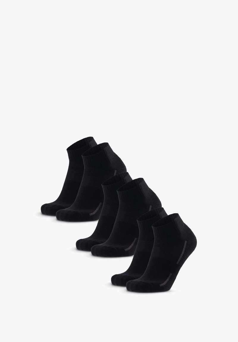 Calcetines negros de tobillo dispuestos en una fila. Están hechos de un material suave y acanalado, con una puntera reforzada y un sutil acento gris en el lateral.