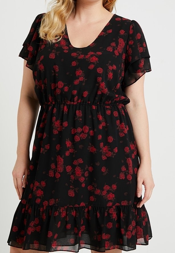 Svart blommig klänning med röda rosor, korta rynkade ärmar, och midja med dragsko samt en volangnederkant. Lättviktig, genomskinlig tyg.