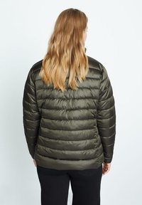 Chaqueta tipo puff con secciones de acolchado horizontal, hecha de material verde oliva brillante. Incluye un cuello alto y detalles de diseño sin costuras.