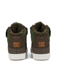 Hnědé a zelené vysoké tenisky s fleecovou podšívkou, gumovými podrážkami a temně hnědým koženým zadním poutkem se žlutým logem.