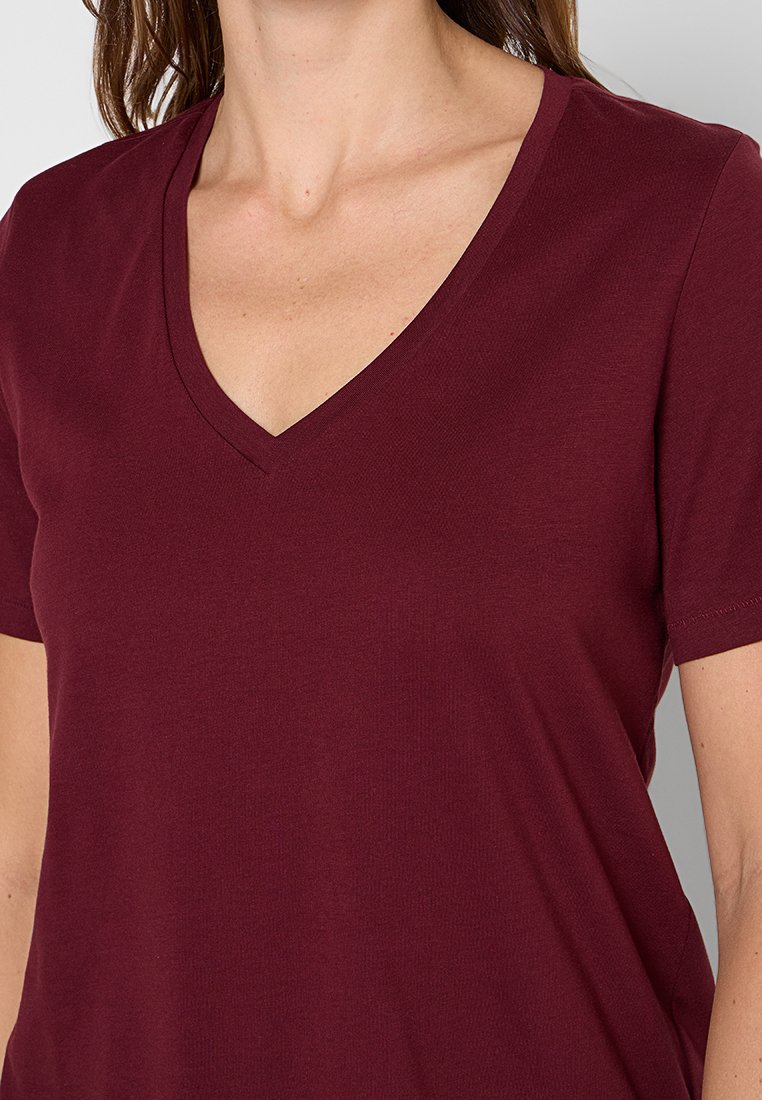 Burgundowa koszulka typu V-neck z krótkim rękawem, wykonana z miękkiego materiału. Posiada prosty design i gładką fakturę, idealna do codziennego noszenia.
