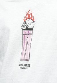 Biele tričko s grafikou lebky v šálke, s plameňmi, ružovými a čiernymi akcentmi a textom "JACK&JONES ORIGINALS" nižšie.