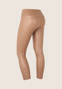 Leggings de cuero sintético en color tostado con una cintura alta, que presentan una textura lisa y elegante y detalles sutiles de costuras a lo largo de los lados.